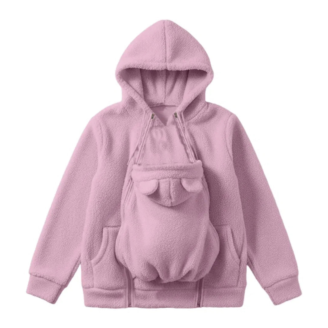 Rosa Sherpa-Fleece-Hoodie als Flat Lay, mit eingezipptem Babytrageeinsatz mit Bärenöhrchen und seitlichen Reißverschlüssen an der Vorderseite. 1