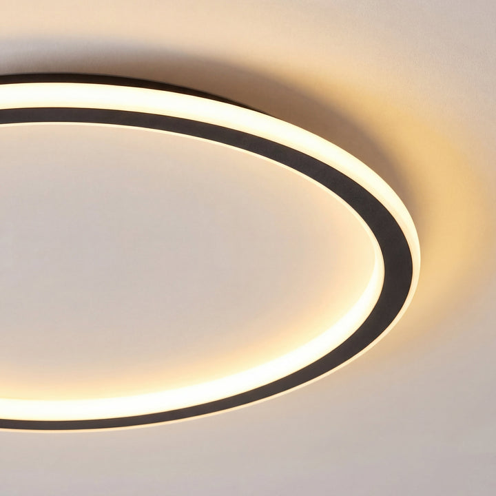 Nahaufnahme eines Ausschnitts der Leuchte mit schwarzem Rahmen und gleichmäßig leuchtendem, warmweißem Diffusor. 2