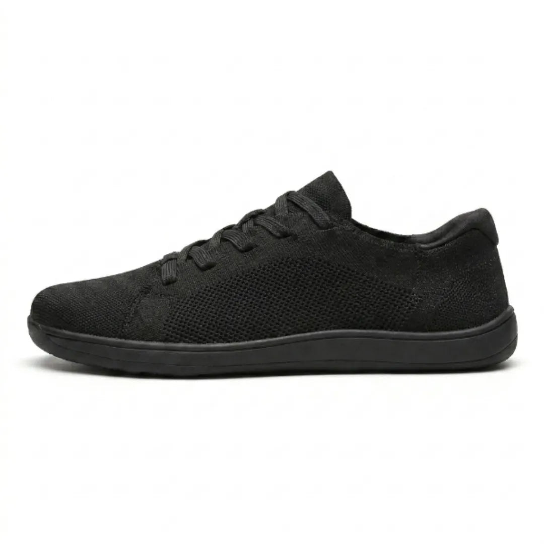 Schwarzer Mesh-Sneaker in Seitenansicht vor weißem Hintergrund, komplett schwarz mit flacher Sohle und Schnürung. 10