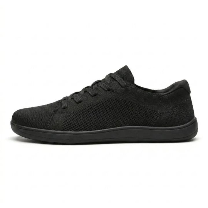 Schwarzer Mesh-Sneaker in Seitenansicht vor weißem Hintergrund, komplett schwarz mit flacher Sohle und Schnürung. 10