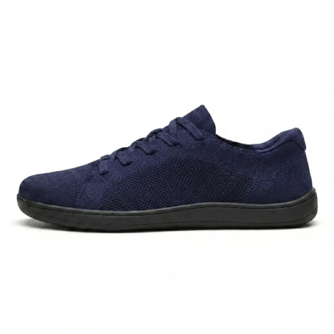 Marineblauer Mesh-Sneaker in Seitenansicht vor weißem Hintergrund, mit Schnürung und flacher schwarzer Sohle. 19