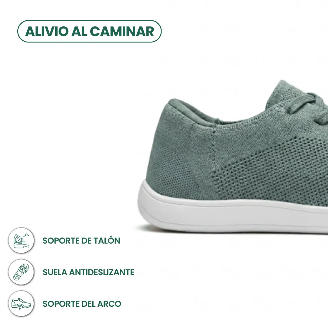 Seitliche Detailansicht der Ferse eines graugrünen Mesh-Sneakers mit weißer Sohle, ergänzt durch Symbole zu Fersenhalt, rutschfester Sohle und Fußgewölbe. 31