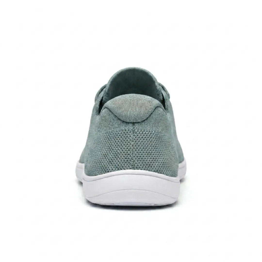 Rückansicht eines graugrünen Mesh-Sneakers mit gepolsterter Fersenkappe und flacher weißer Sohle. 36