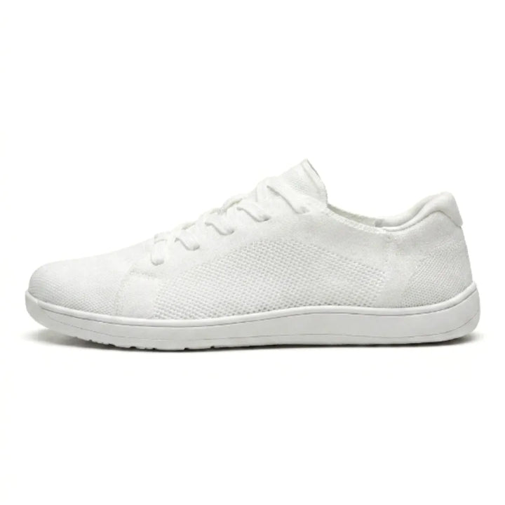 Seitenansicht eines komplett weißen Mesh-Sneakers mit weißer flacher Sohle, Schnürung und perforiertem Strickmuster. 37