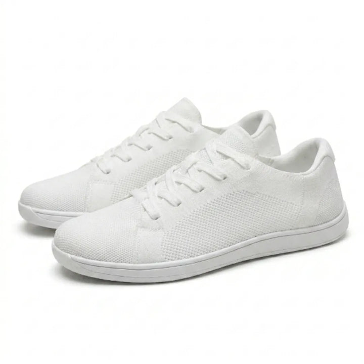 Paar weißer Barfuß-Sneaker aus Mesh mit Schnürung und flacher weißer Sohle, schräg von vorn auf hellem Hintergrund. 43