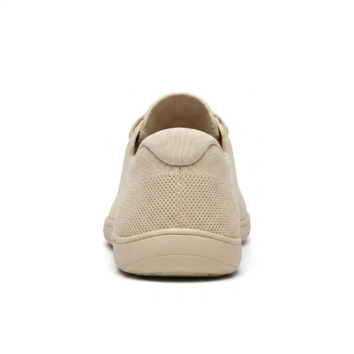 Beiger Sneaker von hinten, zeigt die gepolsterte Fersenkappe, das gelochte Mesh und die flache Sohle. 9