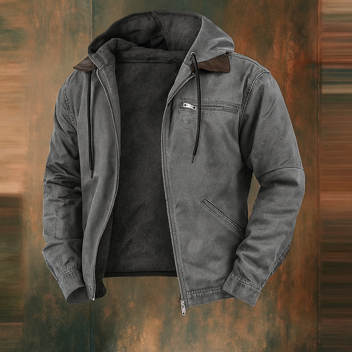 Offene Jacke in Grau mit dunklem Fleecefutter, Kapuze, Brusttasche mit Reißverschluss und braunem Kragen, vor rostfarbenem Hintergrund. 3