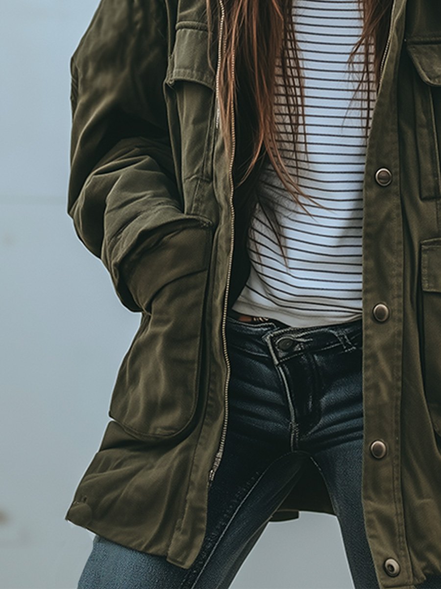 Detailansicht der linken Jackenseite mit Reißverschluss, großer Tasche und Druckknöpfen, offen getragen über gestreiftem Shirt und dunkler Jeans. 4