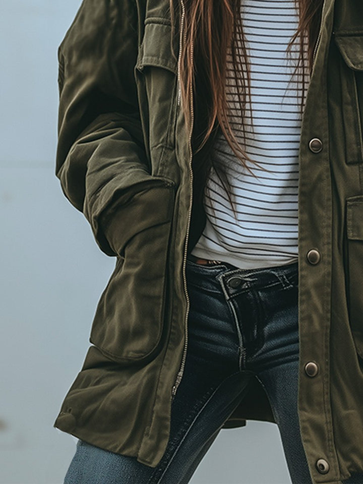 Detailansicht der linken Jackenseite mit Reißverschluss, großer Tasche und Druckknöpfen, offen getragen über gestreiftem Shirt und dunkler Jeans. 4