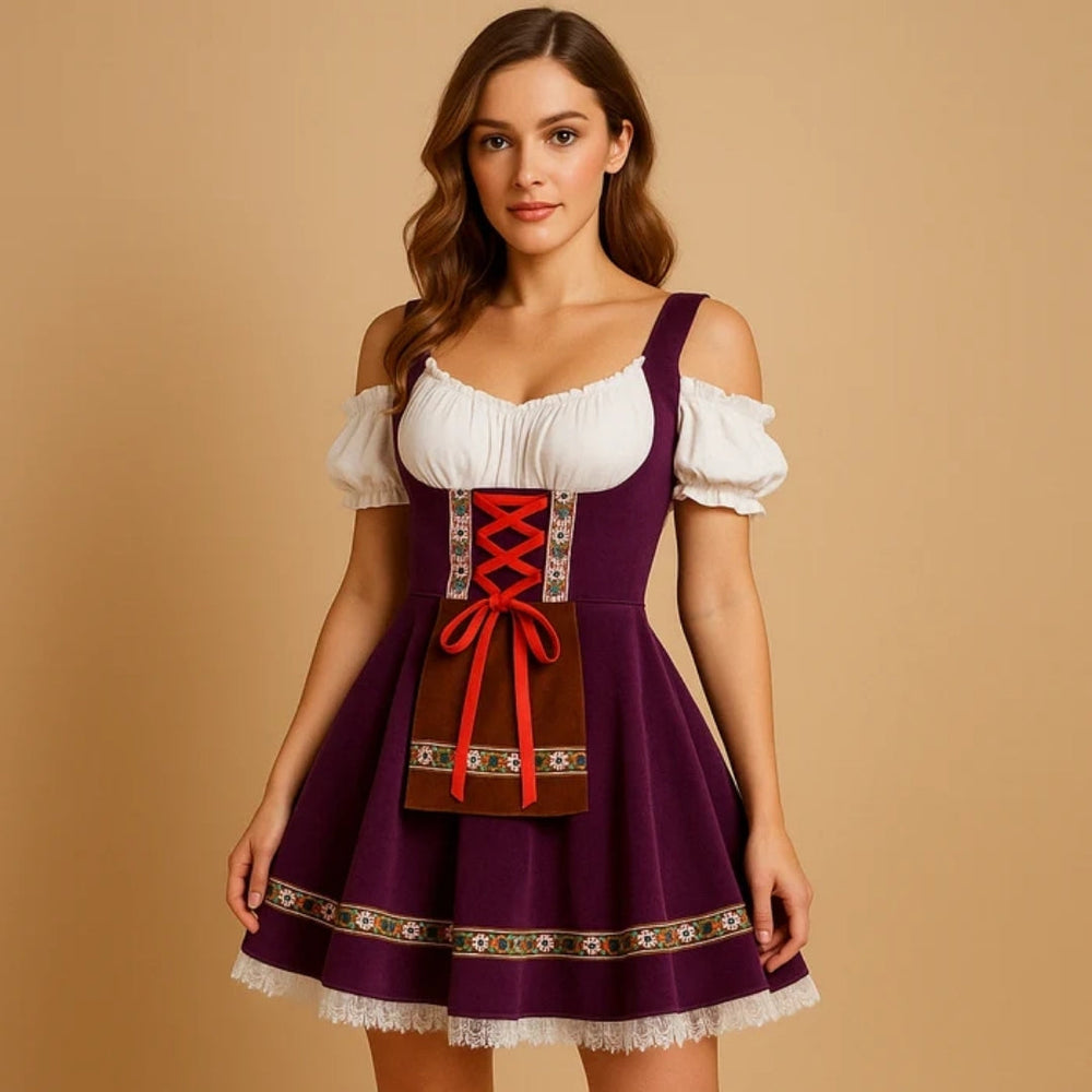 Model im violetten Dirndlkleid mit schulterfreier weißer Bluse, roter Schnürung, brauner Schürzentasche, Blumenborte und weißem Spitzensaum. 2