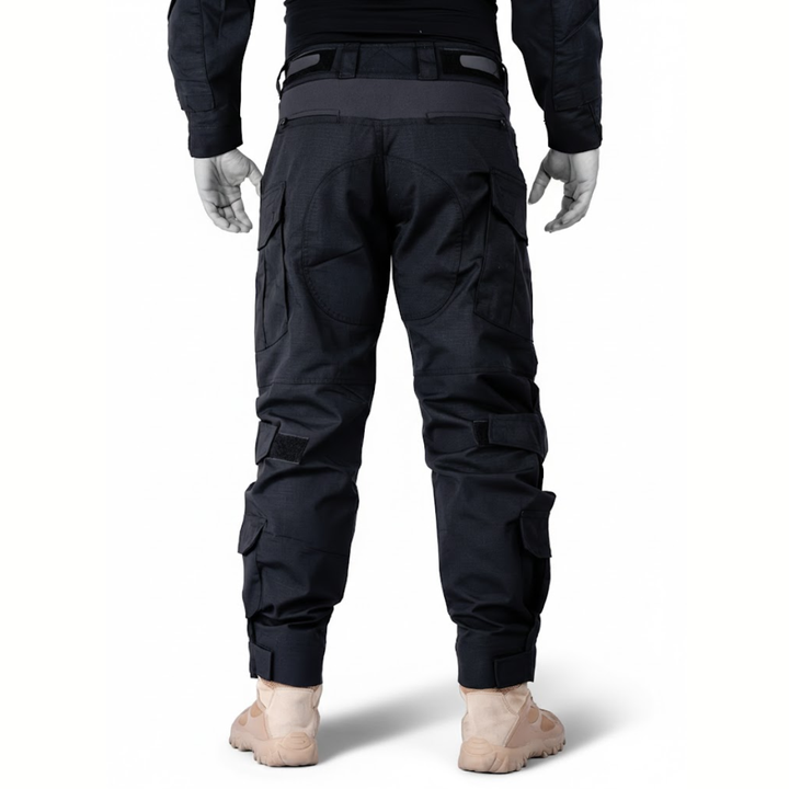 Schwarze Hose an Puppe, direkte Rückansicht mit verstärkter Gesäßpartie, seitlichen Taschen, Klettverschlüssen und Klettbund an den Beinabschlüssen. 10