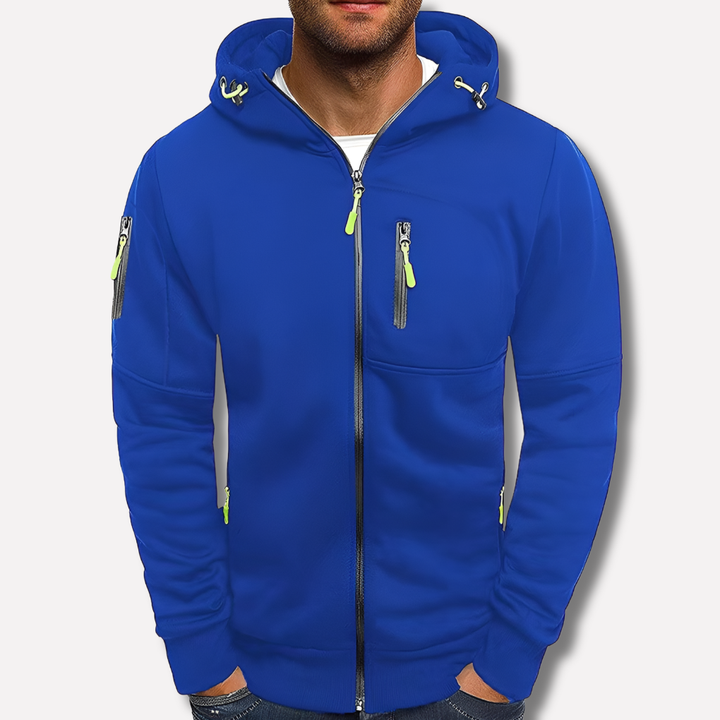 Blauer Kapuzenpullover mit neongrünen Zugbändern und Reißverschlüssen, vor hellem, neutralem Hintergrund von einem Mann getragen. 2