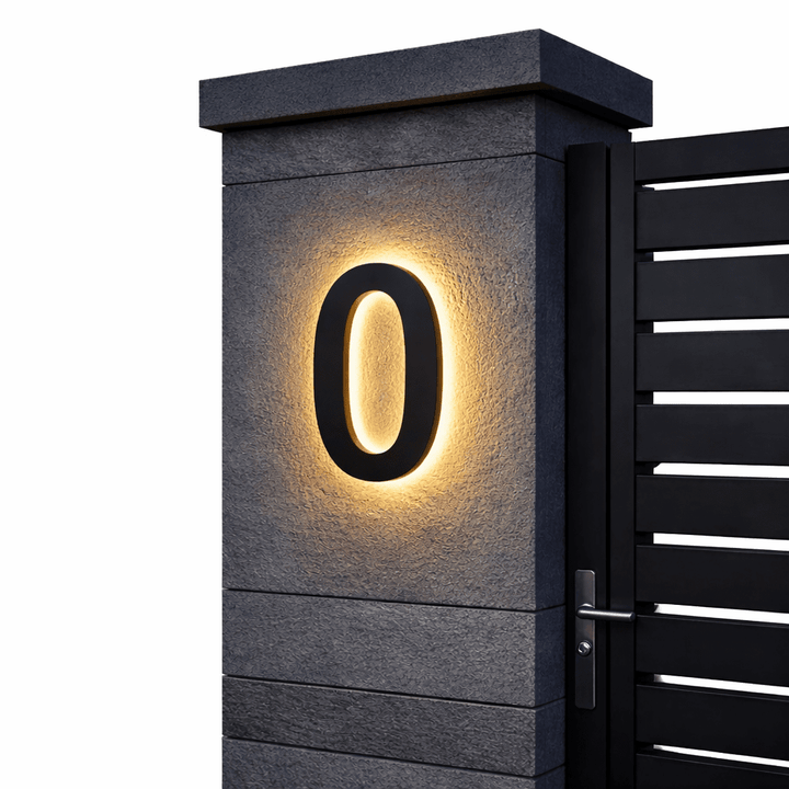Schwarze Ziffer 0 mit warmem Hintergrundlicht an einem grauen Steinpfeiler vor schwarzem Lamellentor, freigestellt. 6