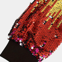 Roter Paillettenstoff mit gelben Akzenten, glänzend, ideal für festliche Kleidung oder Dekoration.