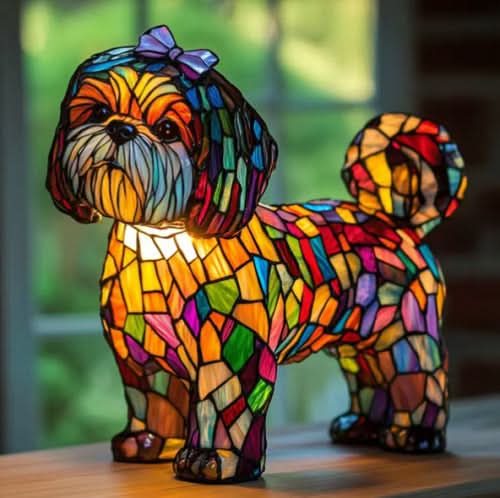 Kleiner zotteliger Hund mit violetter Schleife als Buntglas-Lampe, auf einem Holztisch vor einem Fenster mit grünem Hintergrund. 23
