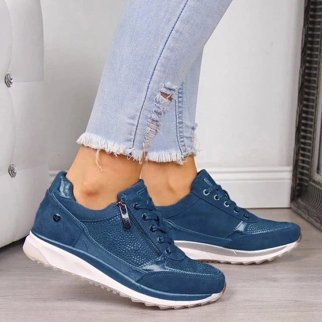 Getragener Schnürschuh in Blau mit seitlichem Reißverschluss, Strassbesatz und weißer Sohle, dazu zerrissene hellblaue Jeans. 5