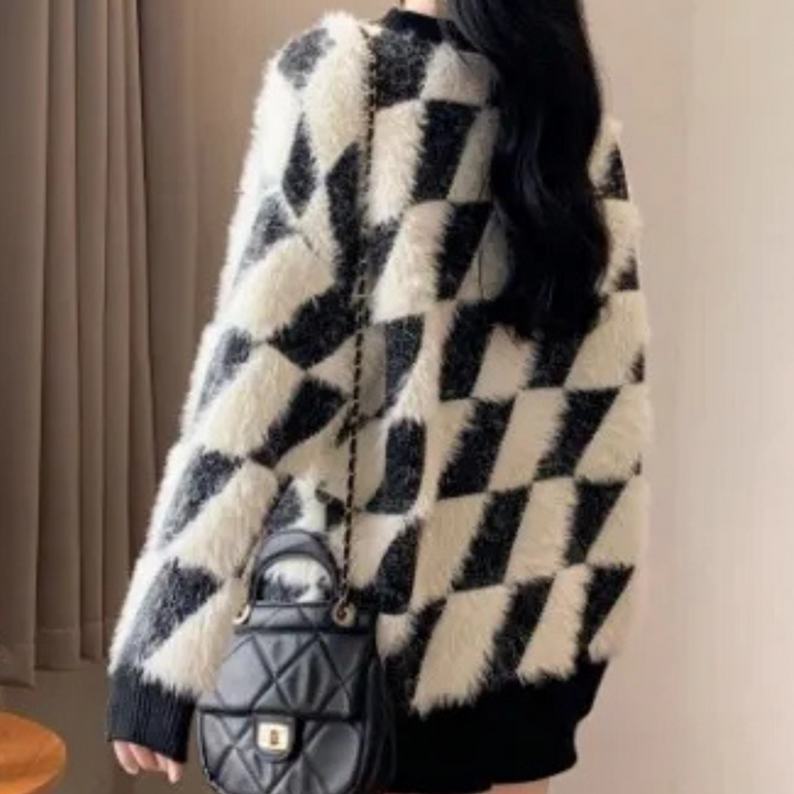 Frau mit schwarz-weiß kariertem Pullover und schwarzer Ledertasche, modisch, elegant.