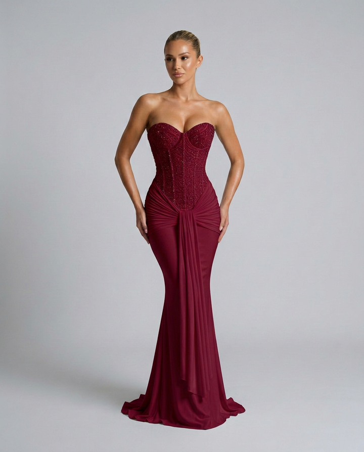 Weinrotes Kleid in leicht gedrehter Pose mit den Händen an der Hüfte, die schmale Silhouette mit ausgestelltem Saum betont 5