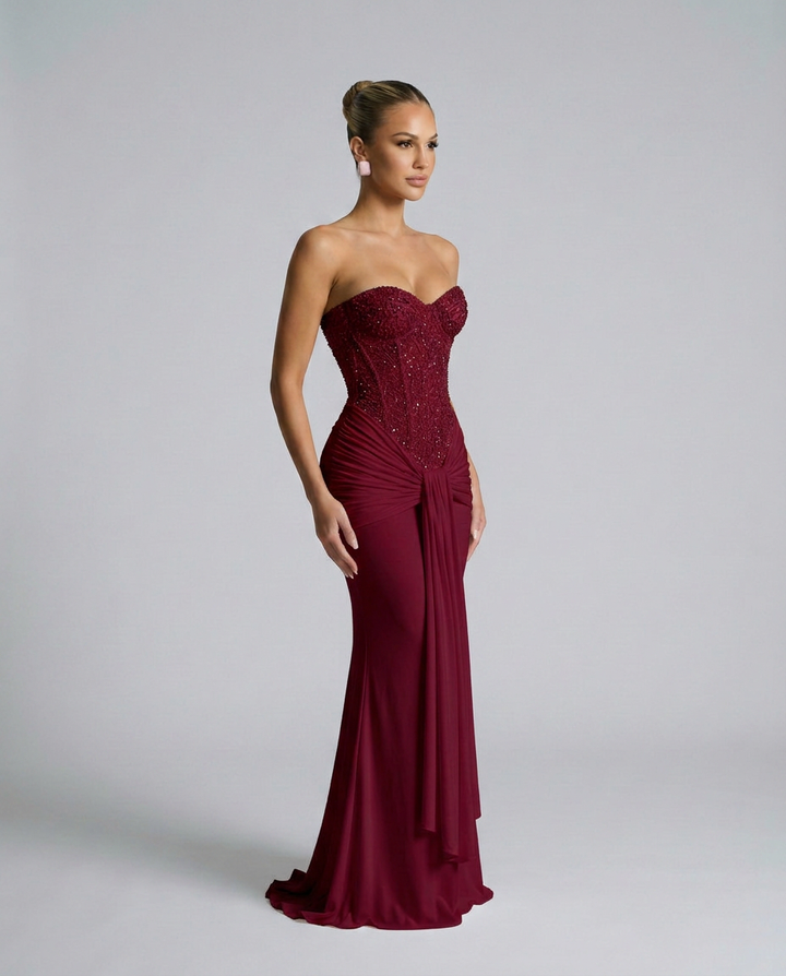 Weinrotes Kleid in seitlicher Dreiviertelansicht, die Pailletten am Oberteil und der Faltenwurf an der Hüfte sind erkennbar 4