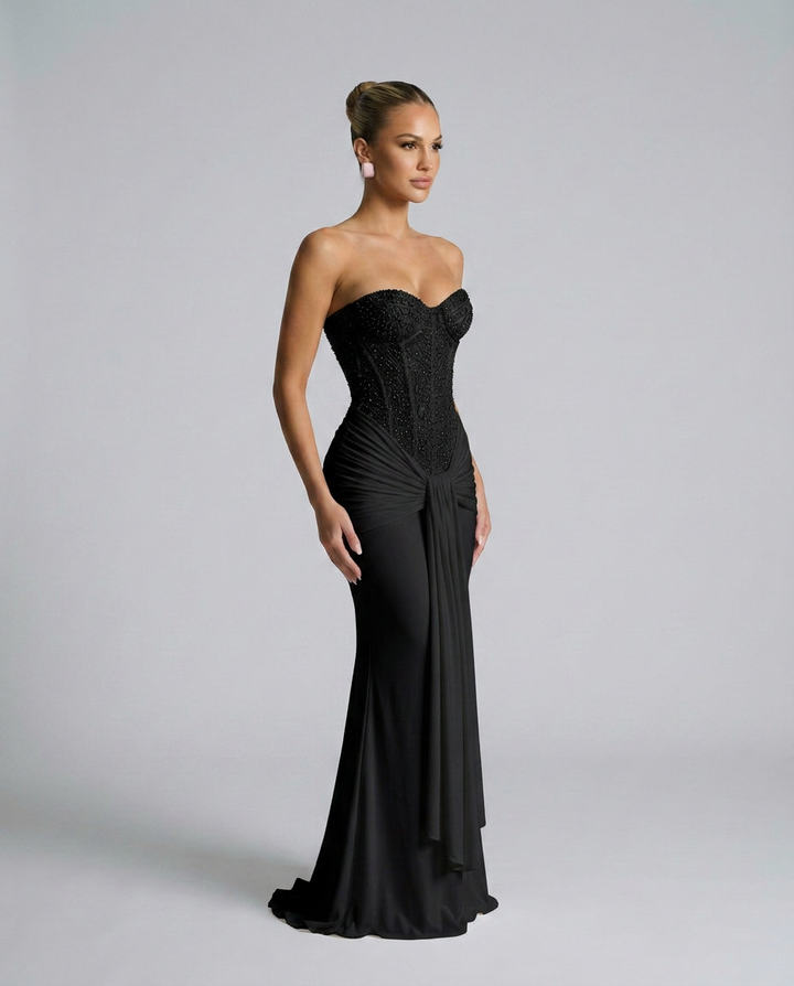 Schwarzes Maxikleid in seitlicher Dreiviertelansicht, die Drapierung und der fließende Rock mit kleiner Schleppe sind gut 2