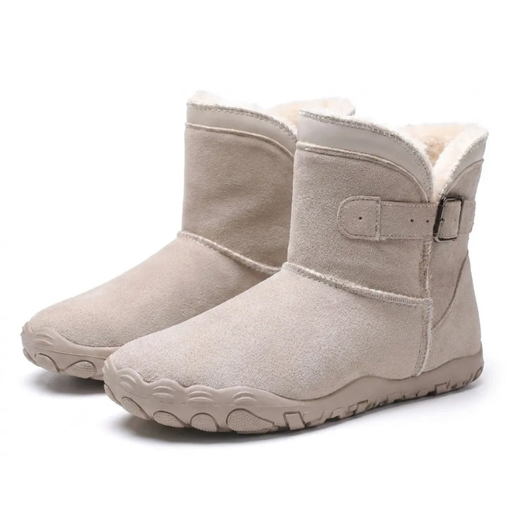Paar cremebeiger Wildlederstiefel mit Fellfutter, Schnallenriemen und breiter Profilsohle im Schrägblick 34