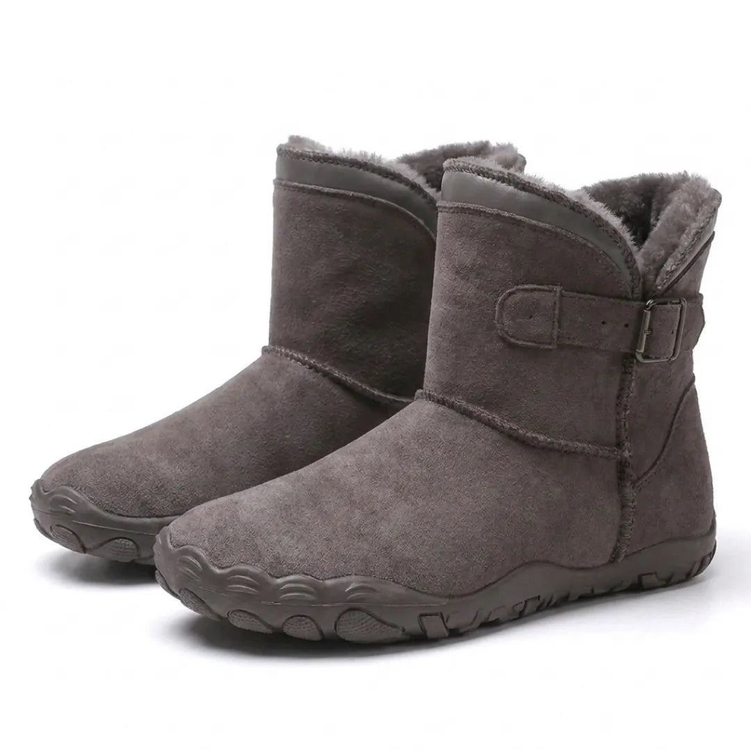 Paar graubraune Stiefel mit flauschigem Futter, seitlicher Schnalle und profilierter Barfußsohle, schräg von vorne 43