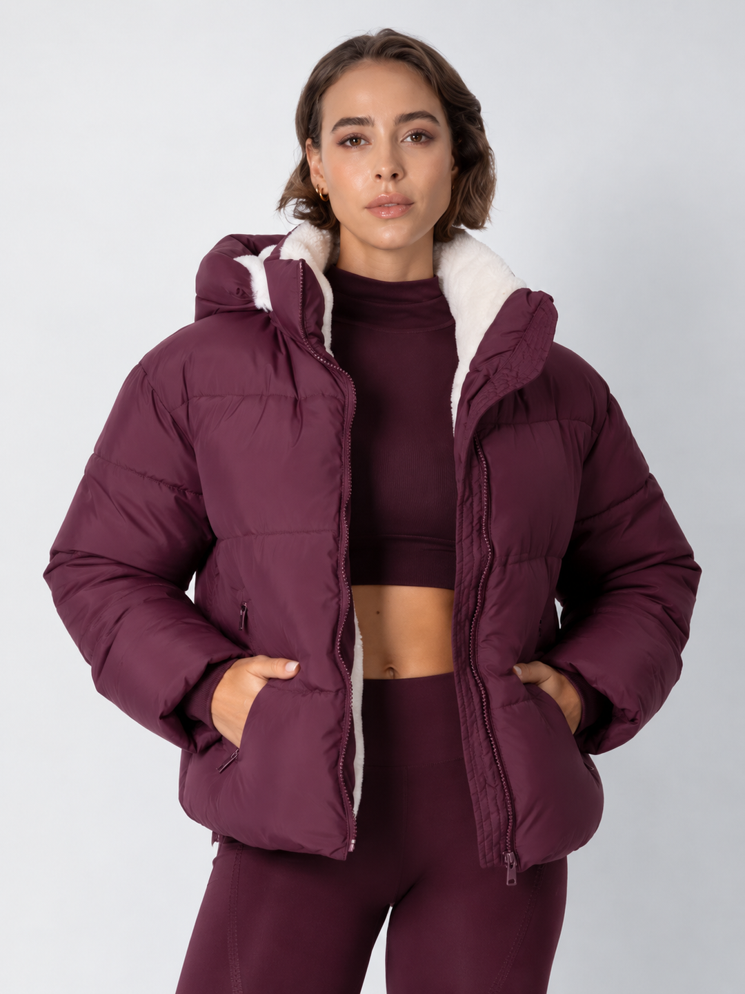 Frontansicht der bordeauxroten Steppjacke mit hellem Fleecefutter, Hände in den Taschen, ĂĽber Crop-Top 16
