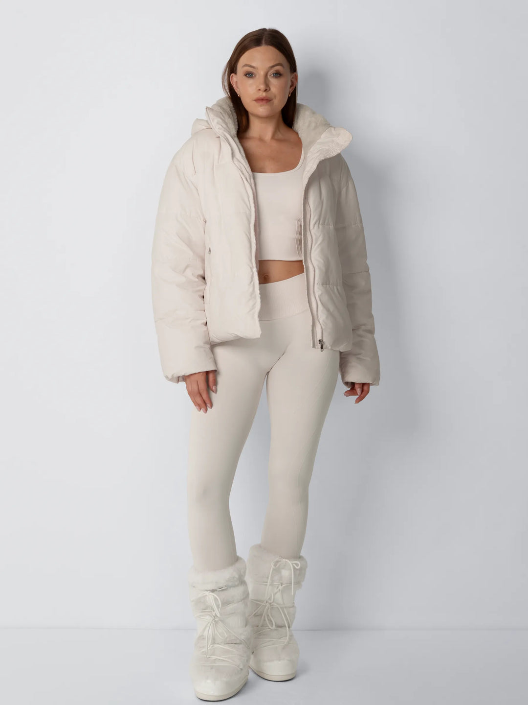 Ganzkörperansicht der cremefarbenen Steppjacke, offen getragen, mit Leggings und flauschigen Winterstiefeln 5