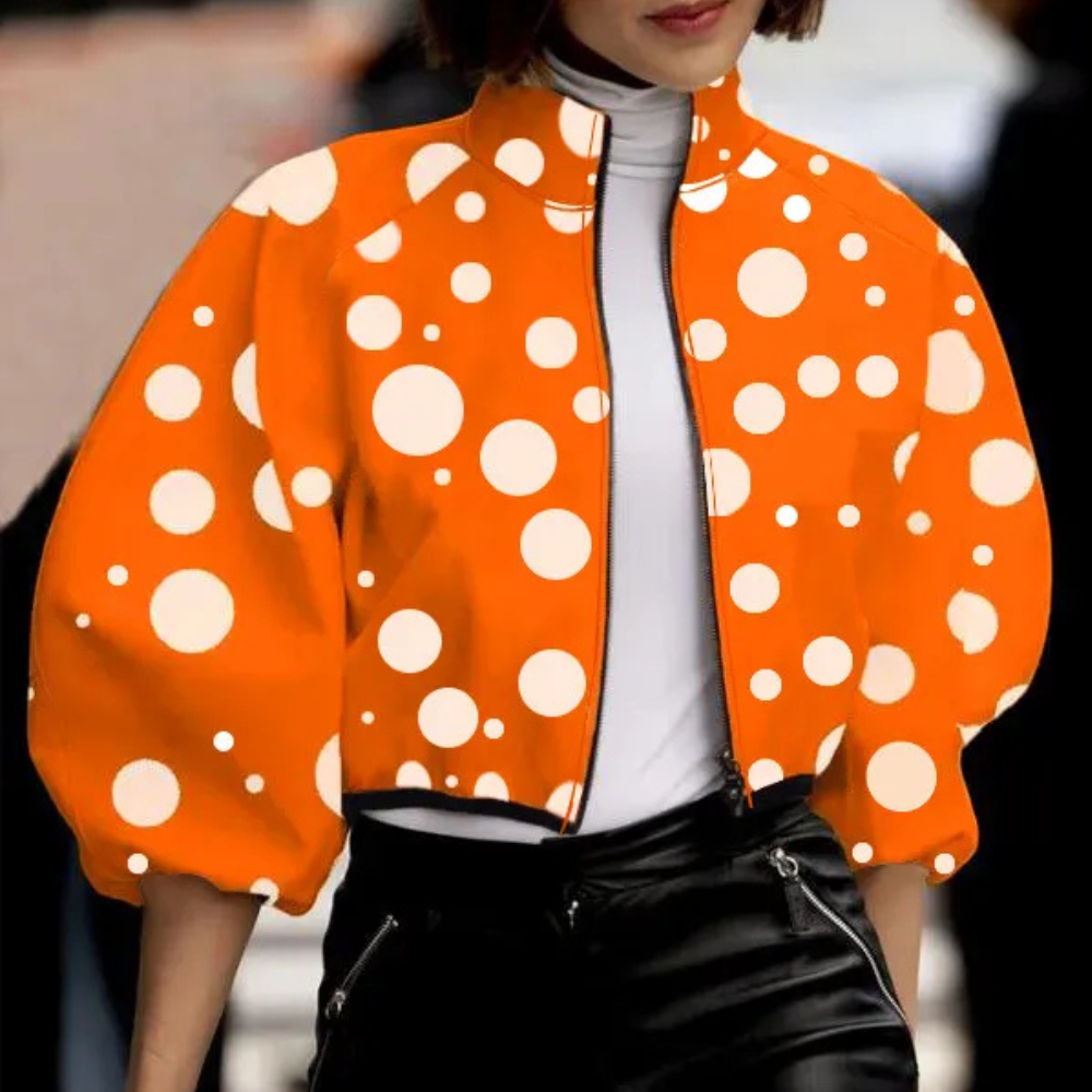 Frau in orange-weißer gepunkteter Jacke, modisch, Herbstmode, Damenbekleidung, Streetstyle.