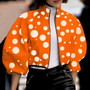 Frau in orange-weißer gepunkteter Jacke, modisch, Herbstmode, Damenbekleidung, Streetstyle.