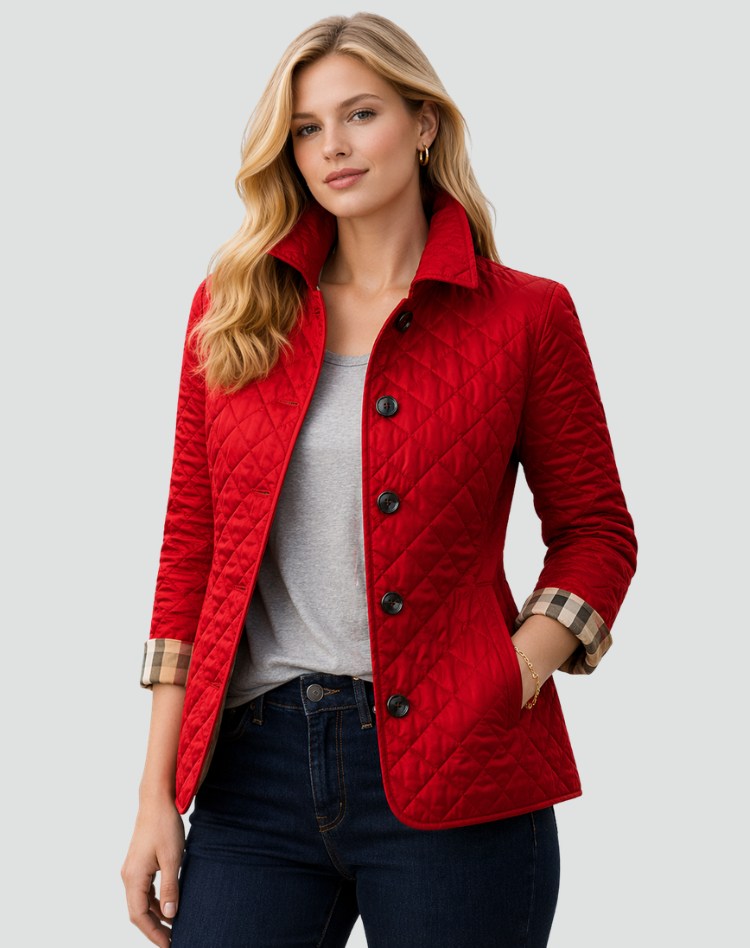 Frau in roter Steppjacke mit dunklen Knöpfen über grauem Shirt und dunkler Jeans, Ärmelaufschläge mit Karomuster sichtbar. 4