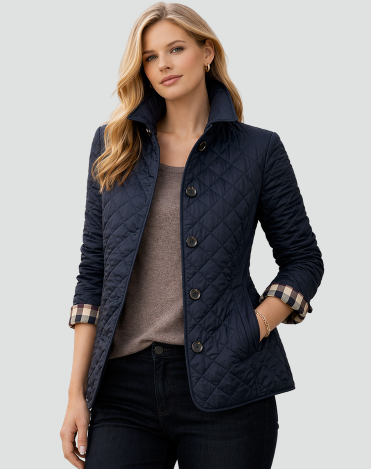 Frau trägt die marineblaue Steppjacke mit hochgestelltem Kragen über braunem Oberteil und dunkler Jeans, Karo-Innenfutter an den Ärmeln. 5