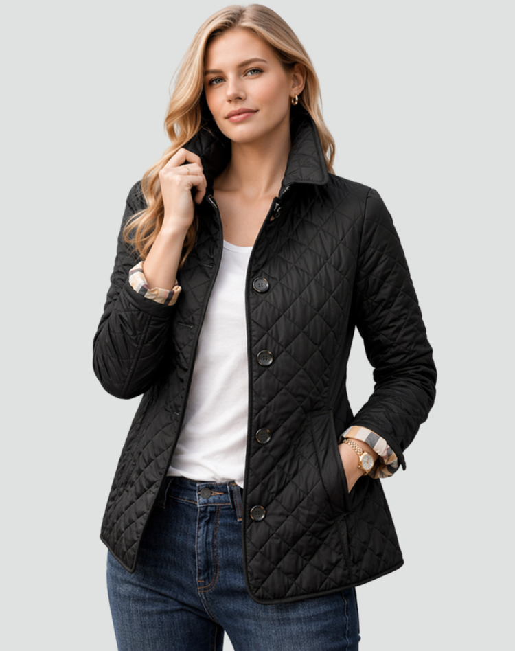 Frau trägt die schwarze Steppjacke offen über weißem Shirt und Jeans, eine Hand in der Tasche, Ärmel mit Karo-Futter umgeschlagen. 1