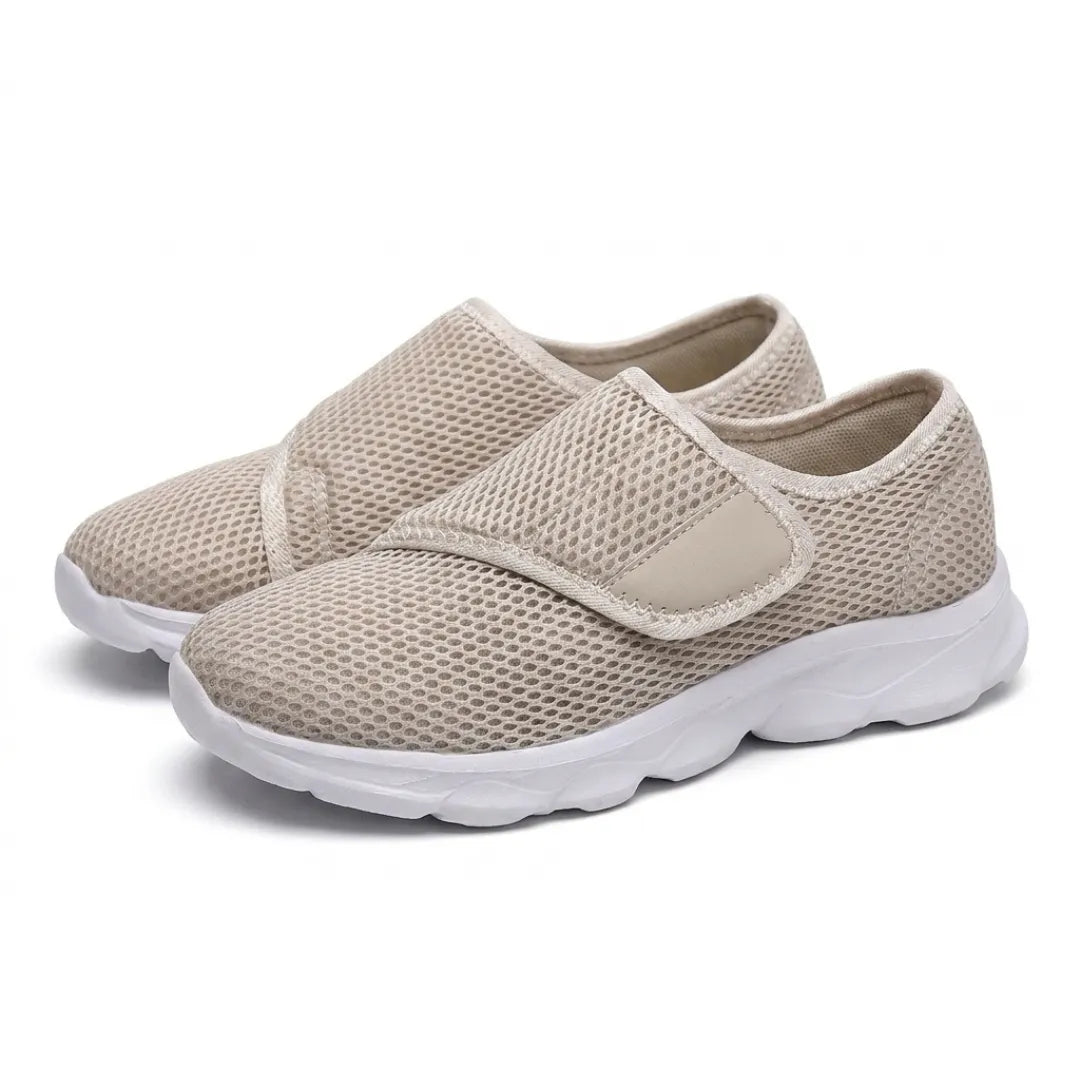 Paar beige Mesh-Schuhe mit weißer Sohle und breitem Klettverschluss, schräg von vorn auf weißem Hintergrund fotografiert. 34