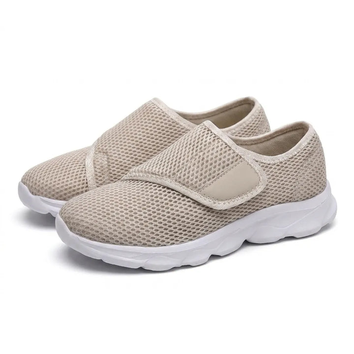 Paar beige Mesh-Schuhe mit weißer Sohle und breitem Klettverschluss, schräg von vorn auf weißem Hintergrund fotografiert. 34