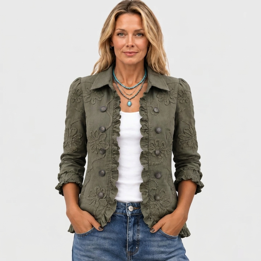 Frontansicht der olivgrünen Jacke am Model, mit Hemdkragen, Blumenstickerei und Rüschenbesatz, kombiniert mit weißem Top und Jeans. 2