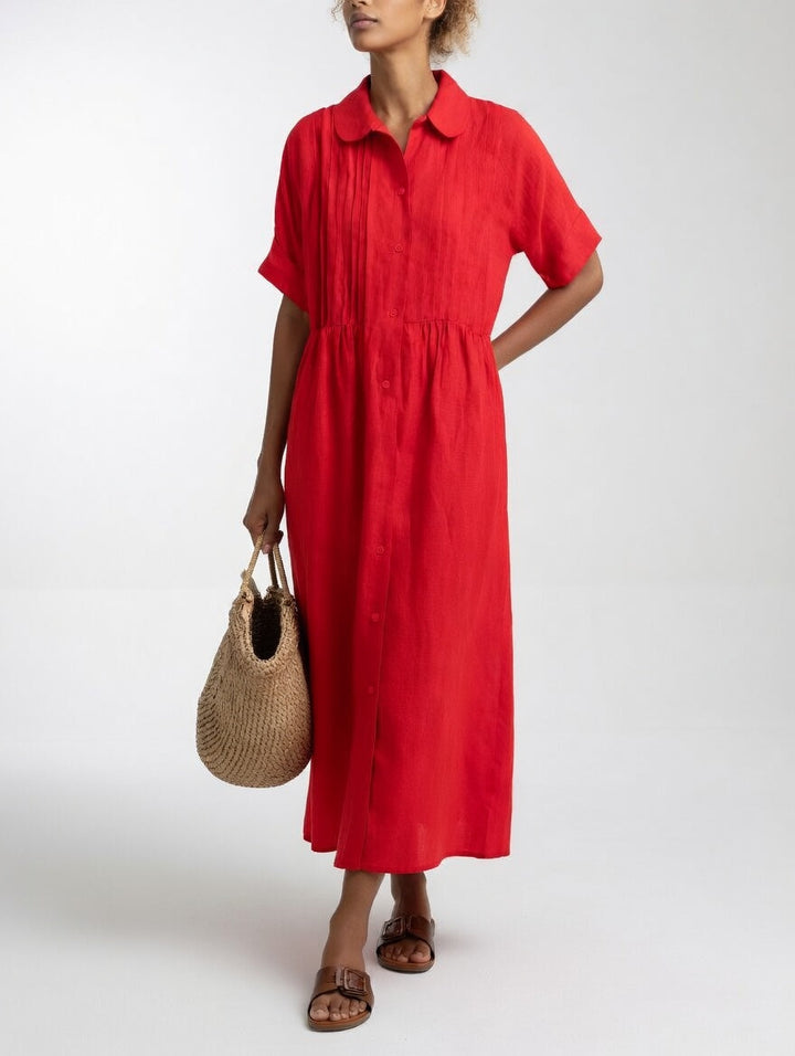 Das Hemdkleid in leuchtendem Rot von vorn, mit durchgehender Knopfleiste, Strohtasche in der Hand und braunen Sandalen. 5