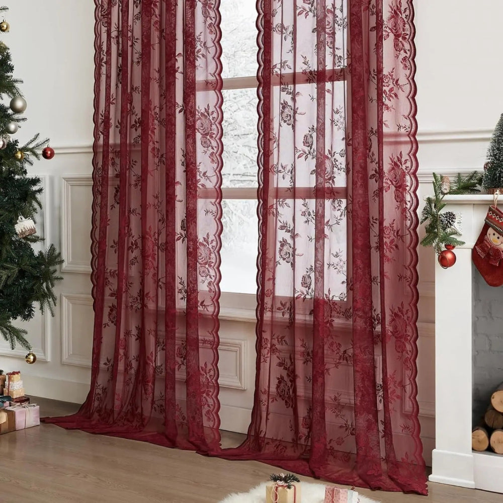 Zwei weinrote Spitzenpaneele mit Rosenmuster vor einem Fenster in weihnachtlich dekoriertem Raum mit Tannenbaum und Kamin. 2