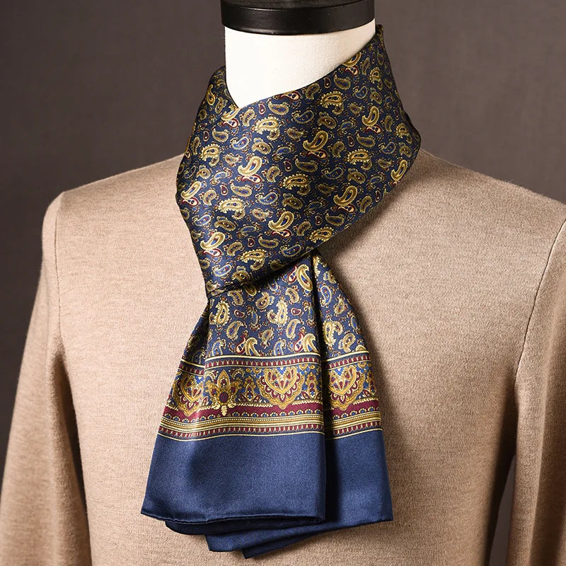 Blauer Seidenschal mit goldenem Paisleymuster und bordeauxfarbener Zierbordüre, an einer Büste über beigem Pullover getragen. 12