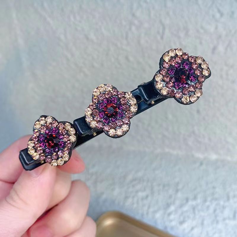 Einzelne Haarspange mit drei Strassblüten in Violett- und Goldtönen, in der Hand gehalten. 2