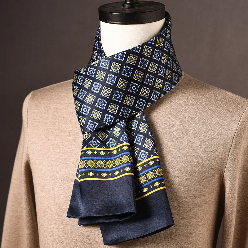 Dunkelblauer Seidenschal mit blau-gelben Quadratmotiven und gelb-blauer Bordüre, an einer Büste über beigem Pullover drapiert. 22