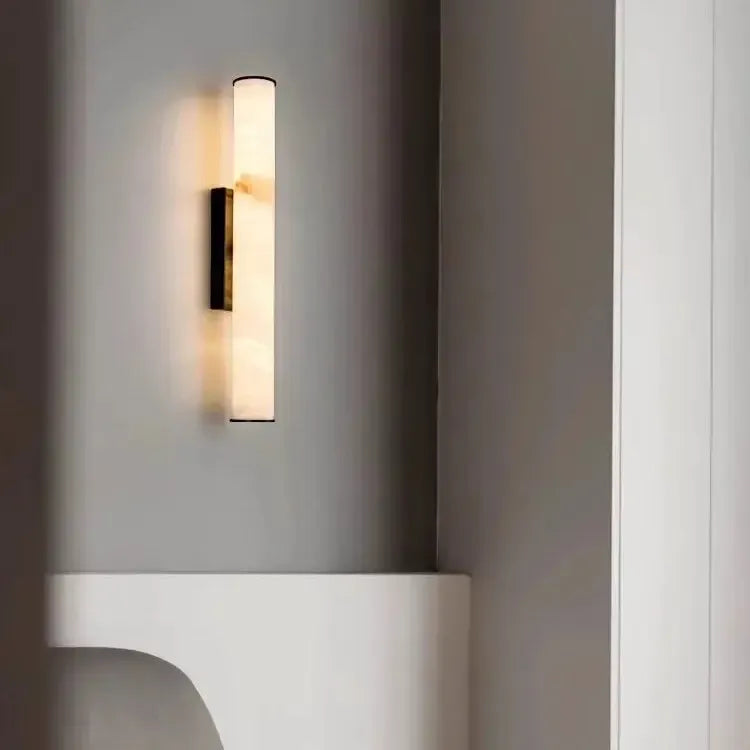 Marmor-Wandleuchte mit dunklen Kappen an grauer Wand über einer weißen, geschwungenen Ablage in einem minimalistischen Interieur. 20