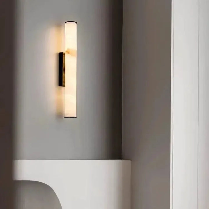 Marmor-Wandleuchte mit dunklen Kappen an grauer Wand über einer weißen, geschwungenen Ablage in einem minimalistischen Interieur. 20