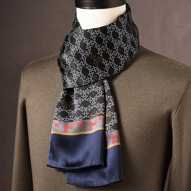 Dunkler Seidenschal mit weißem Punktmuster, roten Hirschmotiven in der Bordüre und blauem Rand, über olivgrünem Pullover. 16