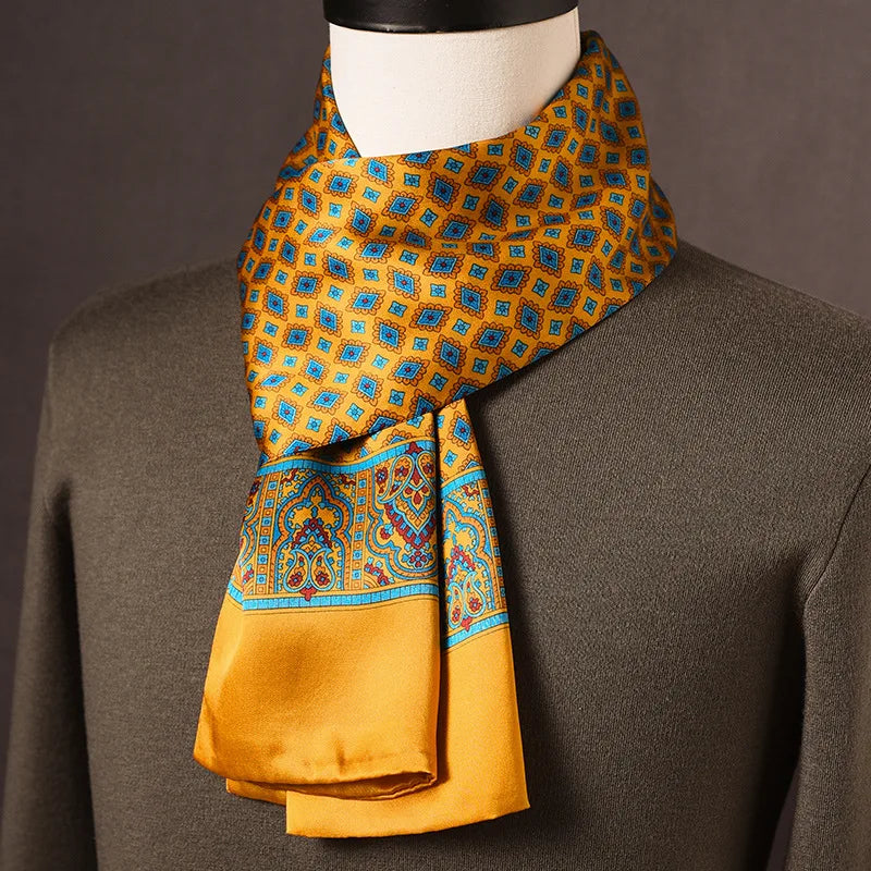 Goldgelber Seidenschal mit blauen Rautenmotiven und verzierter Paisley-Bordüre, an einer Büste über olivgrünem Pullover getragen. 5