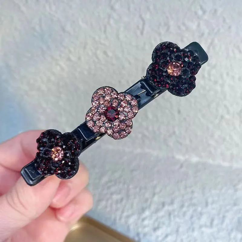 Einzelne Haarspange mit drei Strassblüten in Dunkelrot und Altrosa, die mittlere Blüte heller, in der Hand gehalten. 4