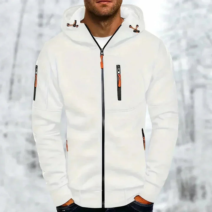 Mann im weißen Kapuzenpullover mit orangefarbenen Reißverschlusszügern und schwarzem Frontreißverschluss vor verschneitem Waldhintergrund. 3