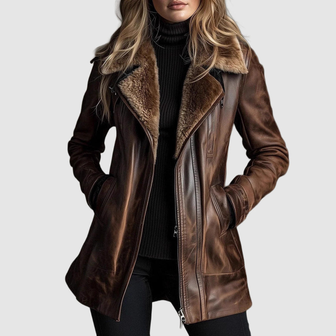 Frontansicht: Model trägt die braune Lederjacke mit Fellkragen offen über schwarzem Rollkragenpullover, Hände in den Taschen 1