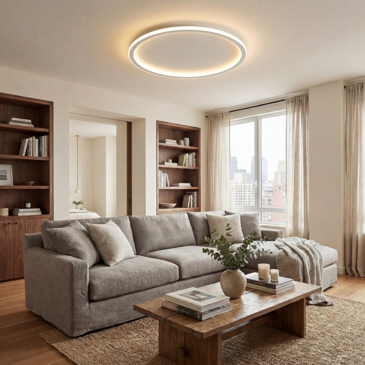 Ringförmige Deckenleuchte in einem Wohnzimmer mit grauem Sofa, Holzregalen, Couchtisch und großem Fenster. 5