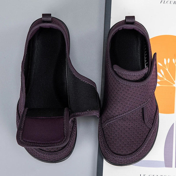Dunkelviolette Klettschuhe von oben, ein Schuh mit geöffnetem Verschluss und schwarzer Innensohle, einer geschlossen 5